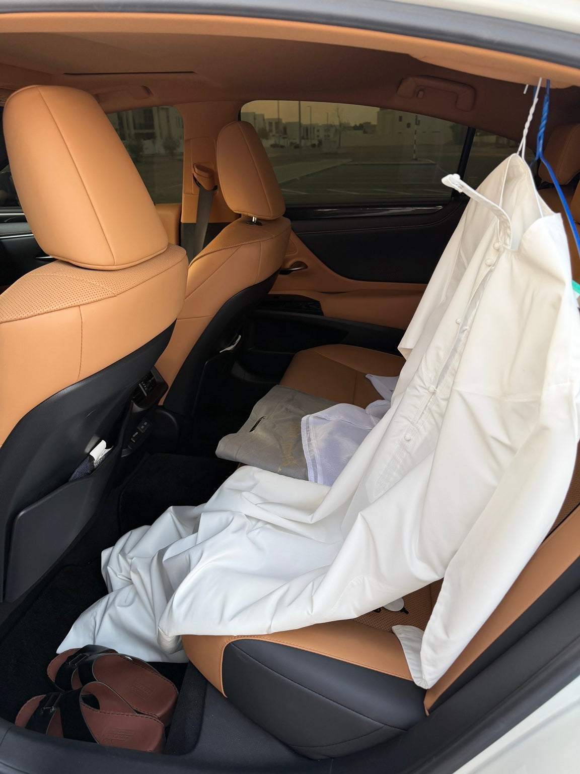 Loose kandura, clothing and sandals on the rear seat without the bag